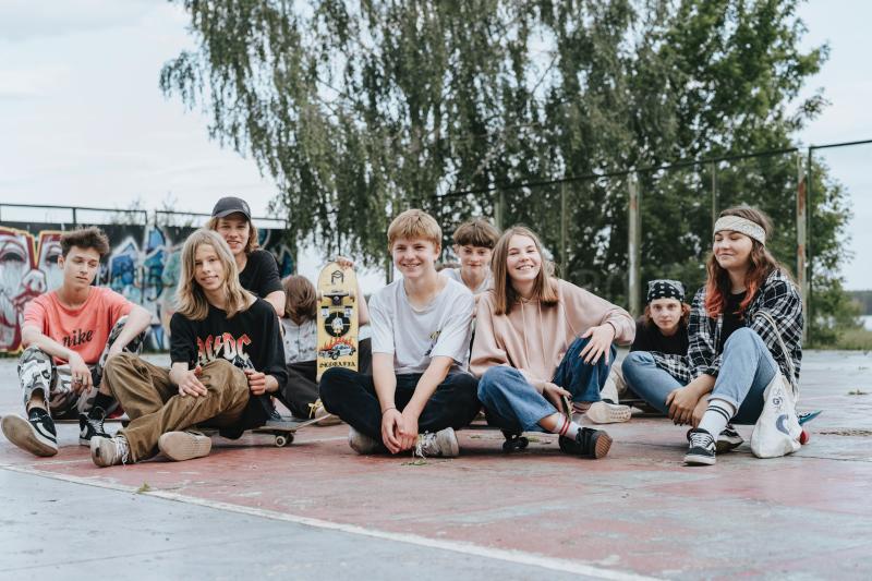 Gruppe von Jugendlichen sitzt am Sportplatz 