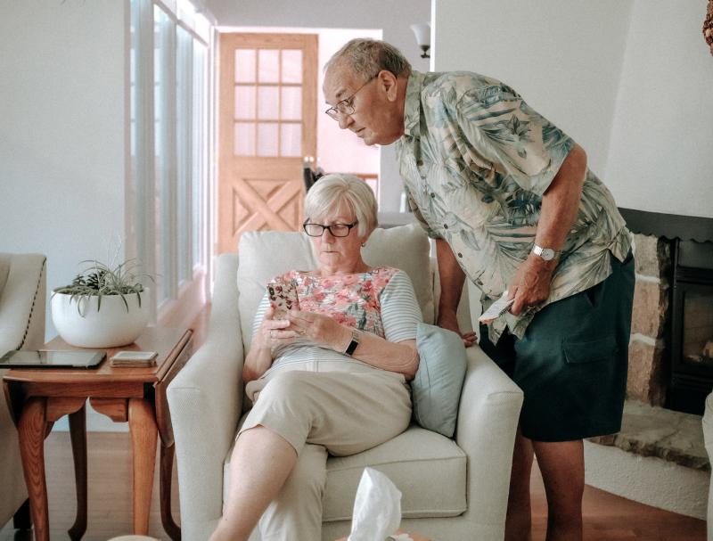 Älteres Ehepaar schaut sich gemeinsam das Handy an.